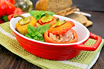 Image showing Pepper stuffed meat in red roaster on dark board