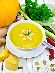 Image showing Soup-puree pumpkin with almonds in bowl on board