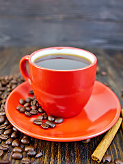 Image showing Coffee in red cup with cinnamon on board