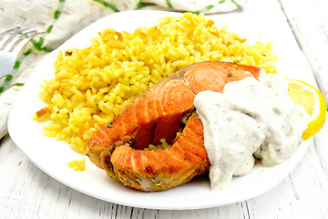 Image showing Salmon with sauce and rice on board