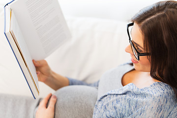 Image showing close up of pregnant woman reading book at home