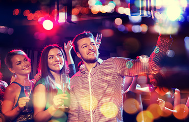 Image showing friends taking selfie by smartphone in night club