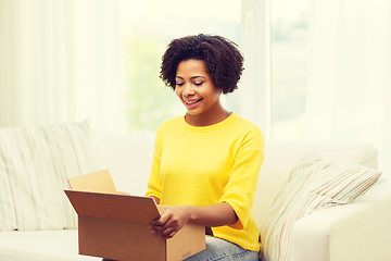 Image showing happy african young woman with parcel box at home