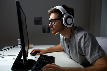 Image showing man in headset playing computer video game at home