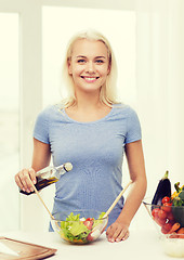 Image showing smiling woman cooking vegetable salad at home