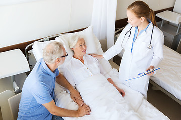 Image showing senior woman and doctor with clipboard at hospital