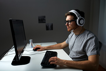 Image showing man in headset playing computer video game at home