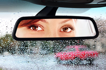 Image showing woman looks to rear-view mirror