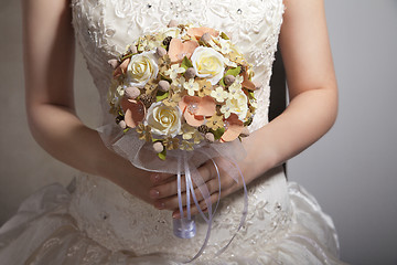 Image showing Bride is holing wedding flowers. Focus on flowers