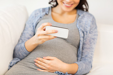 Image showing close up of pregnant woman with smartphone at home