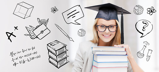 Image showing happy student woman in mortarboard with books