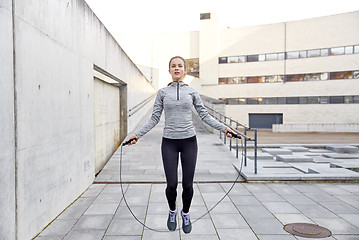 Image showing woman exercising with jump-rope outdoors