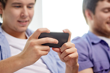 Image showing close up of happy friends with smartphones at home