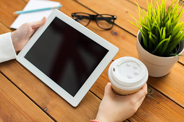 Image showing close up of woman with tablet pc on wooden table