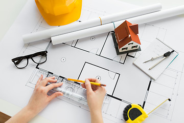 Image showing close up of hands with ruler measuring blueprint