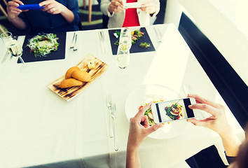 Image showing close up of women picturing food by smartphones