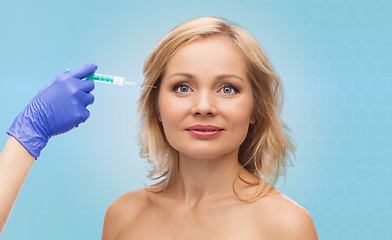 Image showing happy woman face and beautician hand with syringe