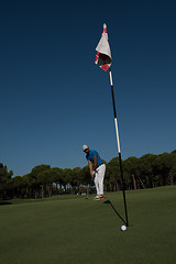 Image showing golf player hitting shot at sunny day