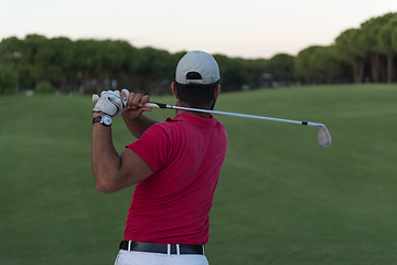 Image showing golfer hitting a sand bunker shot on sunset