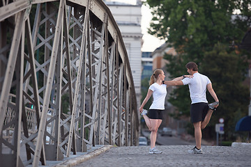 Image showing couple warming up and stretching before jogging