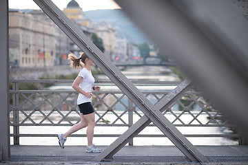 Image showing sporty woman running  on sidewalk