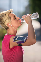 Image showing woman drinking  water after  jogging