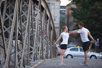 Image showing couple warming up and stretching before jogging