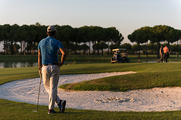 Image showing golfer from back at course looking to hole in distance