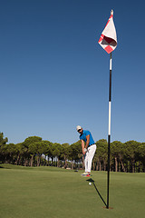 Image showing golf player hitting shot at sunny day