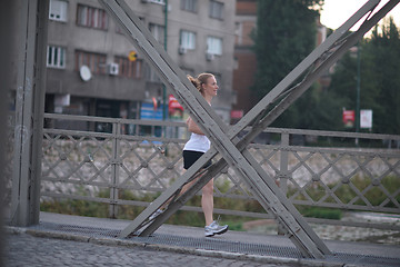 Image showing sporty woman running  on sidewalk