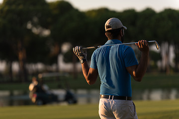 Image showing golfer from back at course looking to hole in distance