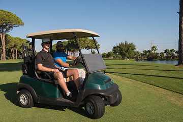 Image showing golf players driving cart at course