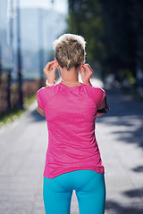 Image showing jogging woman setting phone before jogging