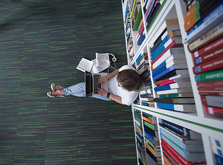 Image showing female student study in library, using tablet and searching for 