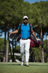 Image showing golf player walking and carrying bag