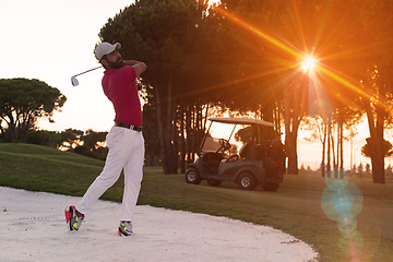 Image showing golfer hitting a sand bunker shot on sunset