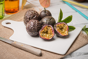 Image showing Passion fruits on white ceramic tray on wooden table background.