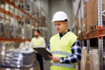 Image showing man with clipboard in safety vest at warehouse