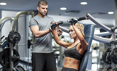 Image showing man and woman flexing muscles on gym machine