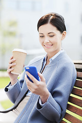 Image showing smiling woman with coffee and smartphone