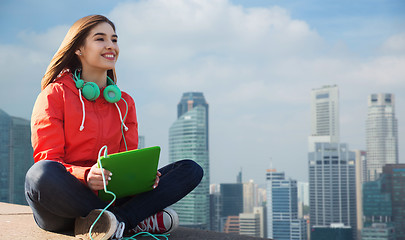 Image showing happy young woman with tablet pc and headphones