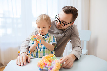 Image showing father and son playing with ball clay at home