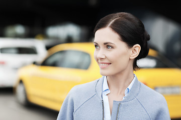 Image showing smiling woman over taxi station or city street