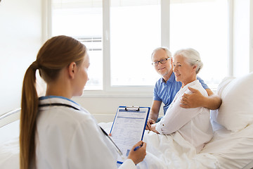 Image showing senior woman and doctor with clipboard at hospital