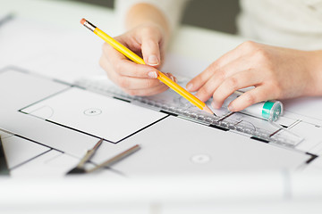 Image showing close up of hands with compass measuring blueprint