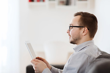 Image showing smiling man working with tablet pc at home