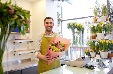 Image showing smiling florist man making bunch at flower shop