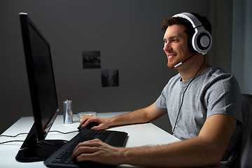 Image showing man in headset playing computer video game at home