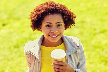 Image showing smiling african woman drinking coffee outdoors 