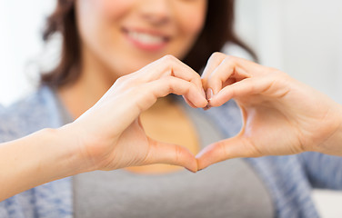 Image showing close up of happy woman showing heart with hands